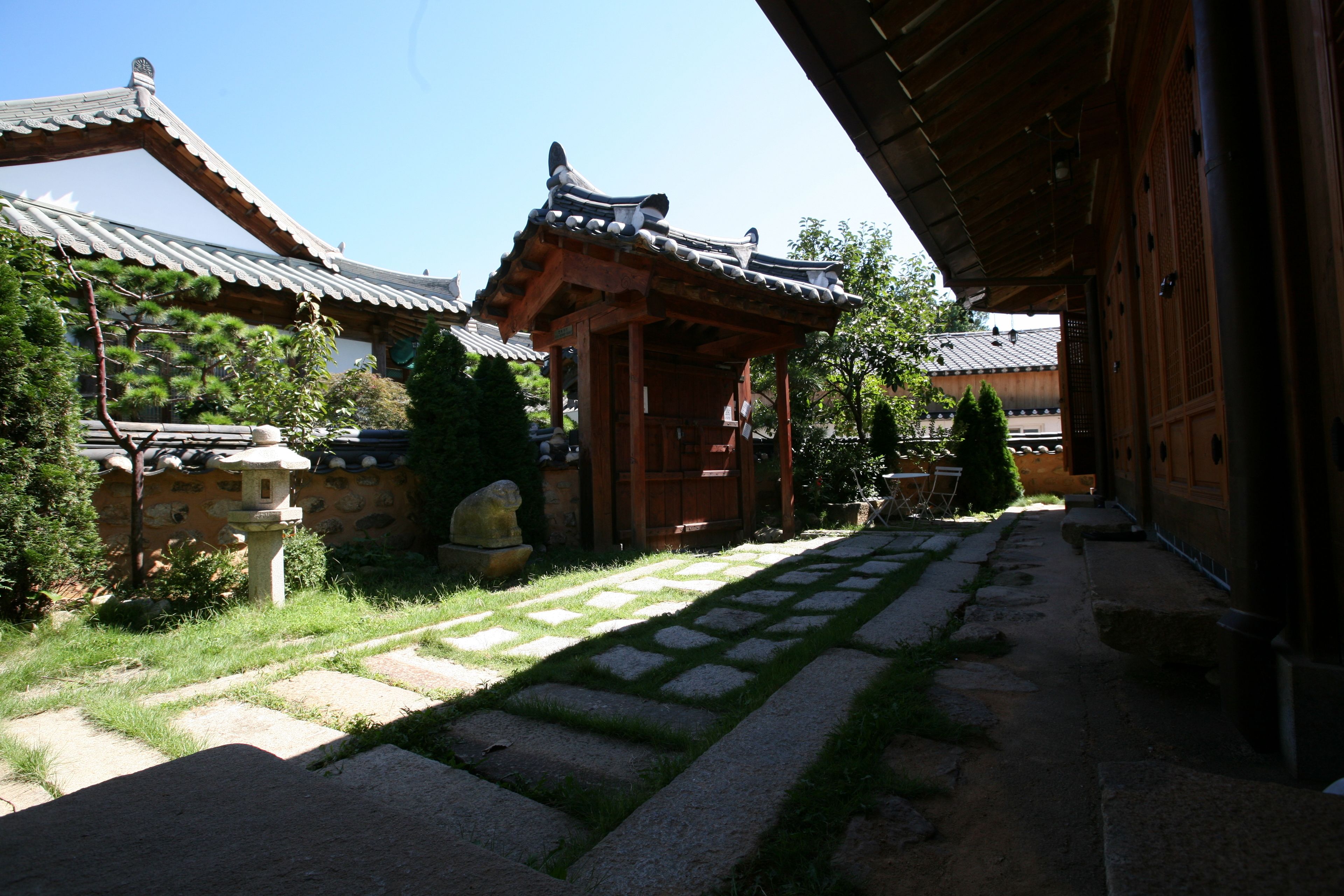 Un bâtiment japonais traditionnel, doté d’un toit en tuiles, d’un chemin en pierre et de structures en bois.