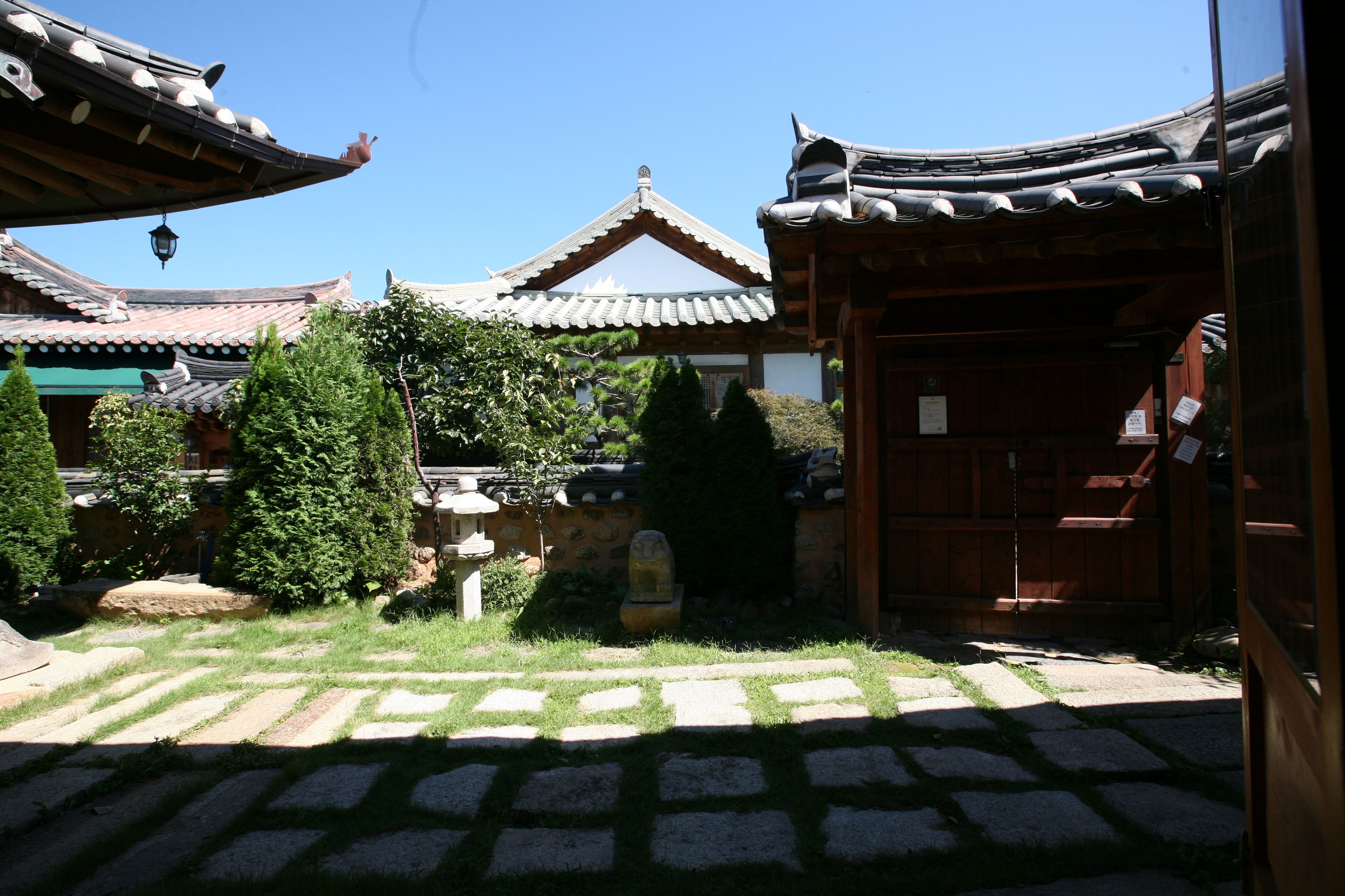 A traditional courtyard with tiled roofs and stone lanterns.