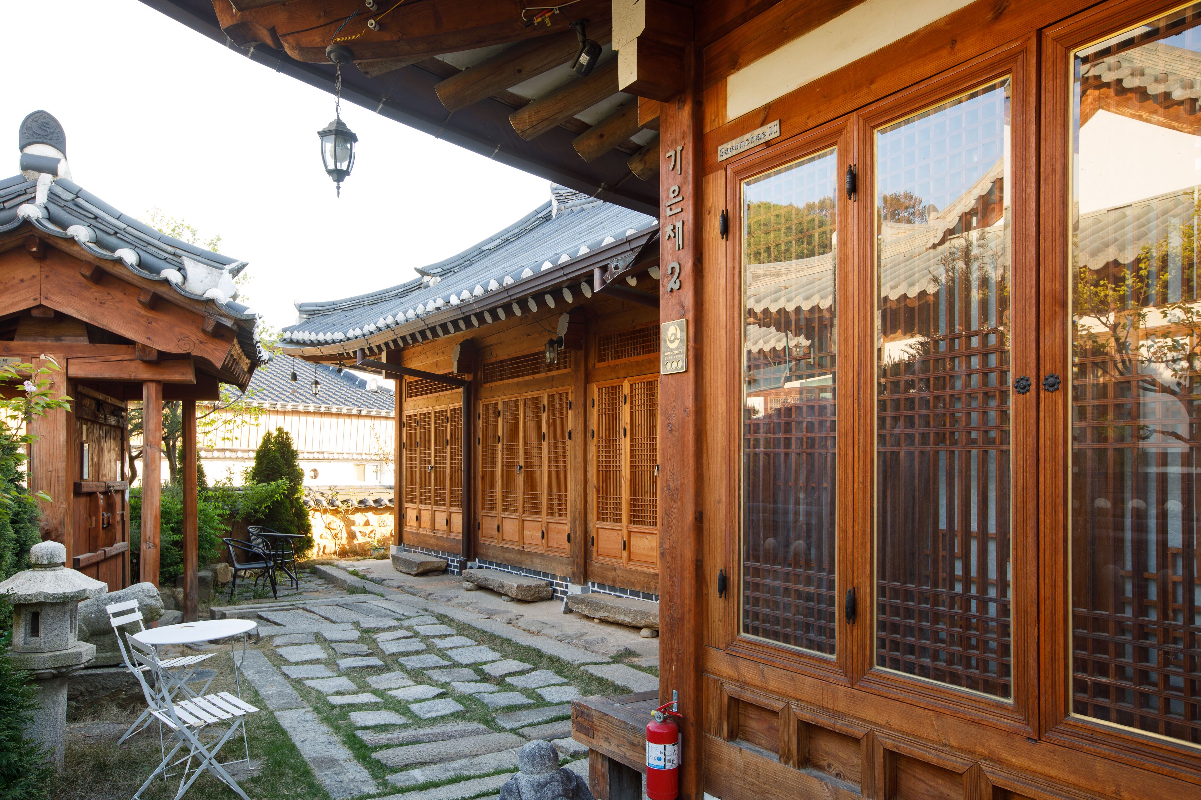 A traditional wooden building with large windows and a stone-paved courtyard.
