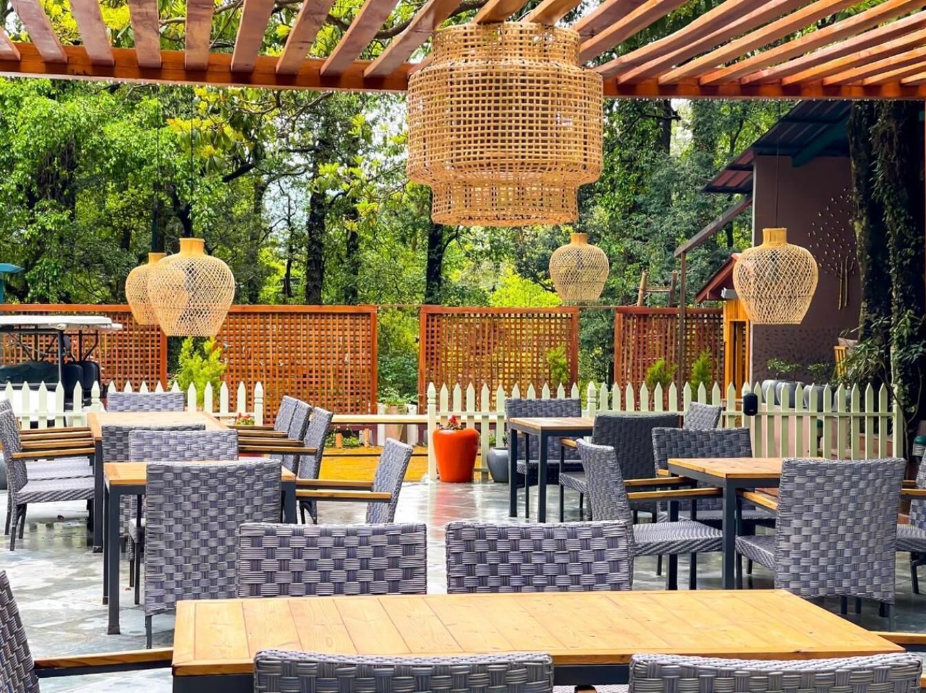An outdoor patio with wicker furniture and hanging rattan lamps.