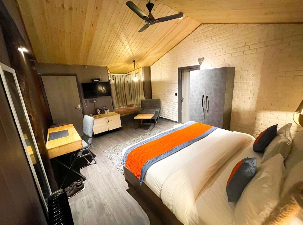 Un dormitorio moderno con cama, escritorio, silla y armario.
