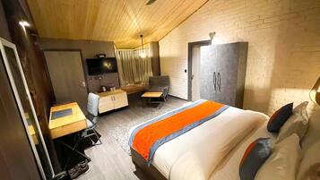Un dormitorio moderno con cama, escritorio, silla y armario.