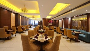 Un restaurante moderno con iluminación amarilla, paneles de madera y una pantalla de televisión.