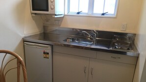 A compact kitchen with a built-in microwave, a sink, and a dishwasher.