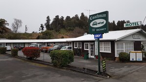 A motel named 'The Coachman' with a sign indicating broadband availability and a 'Vacancy' sign.