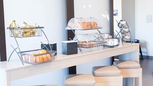 A breakfast bar with fruit baskets and pastries. - Microtel Inn & Suites by Wyndham Springville/Provo (Springville)