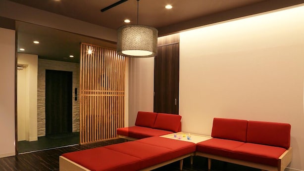 Una habitación moderna con un sofá modular, una mesita y una lámpara colgante.
