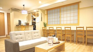 Un salon comprenant un canapé, une table basse et un coin repas avec des chaises et une table.