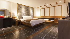 A modern bedroom with a large bed, a bedside table, a nightstand, a built-in wardrobe, and a large window. - Hotel Leaders (Seoul)