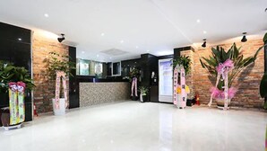 A spacious lobby with a polished floor, a reception desk, and decorative plants. - Hotel Leaders (Seoul)