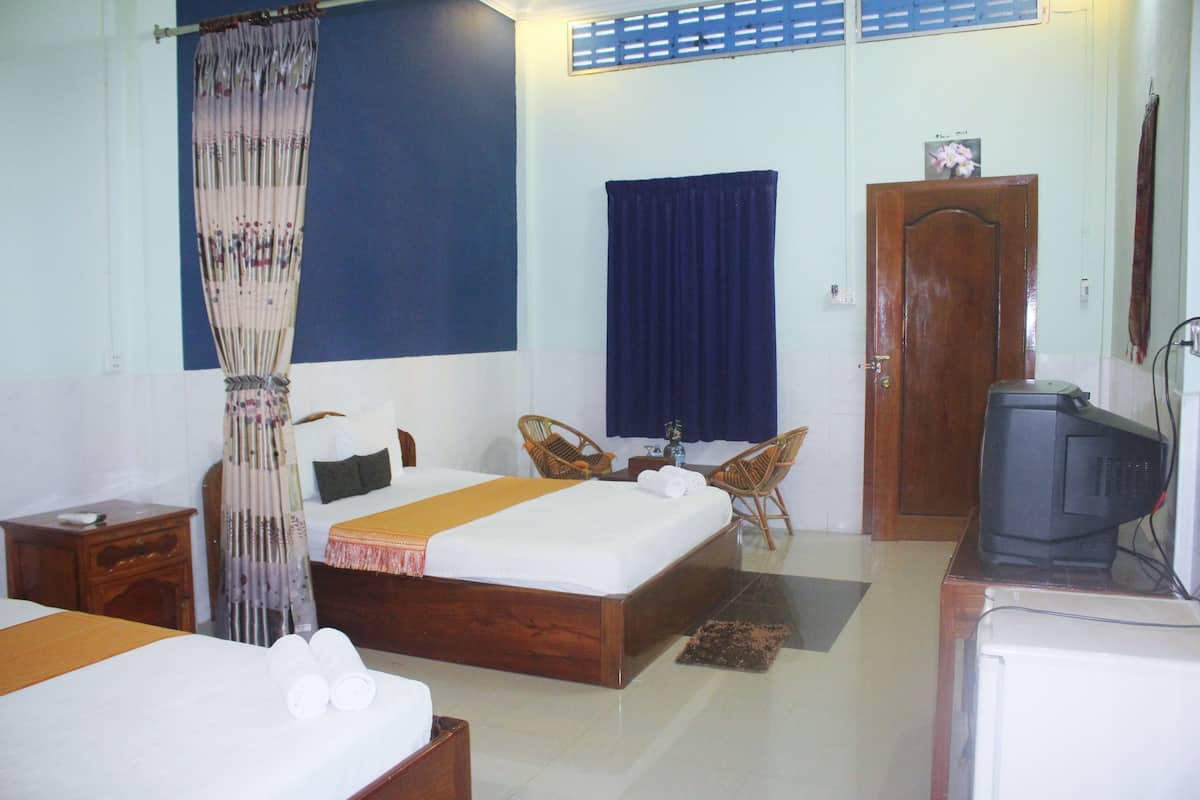 A hotel room with a bed, a television, a desk, and a chair.