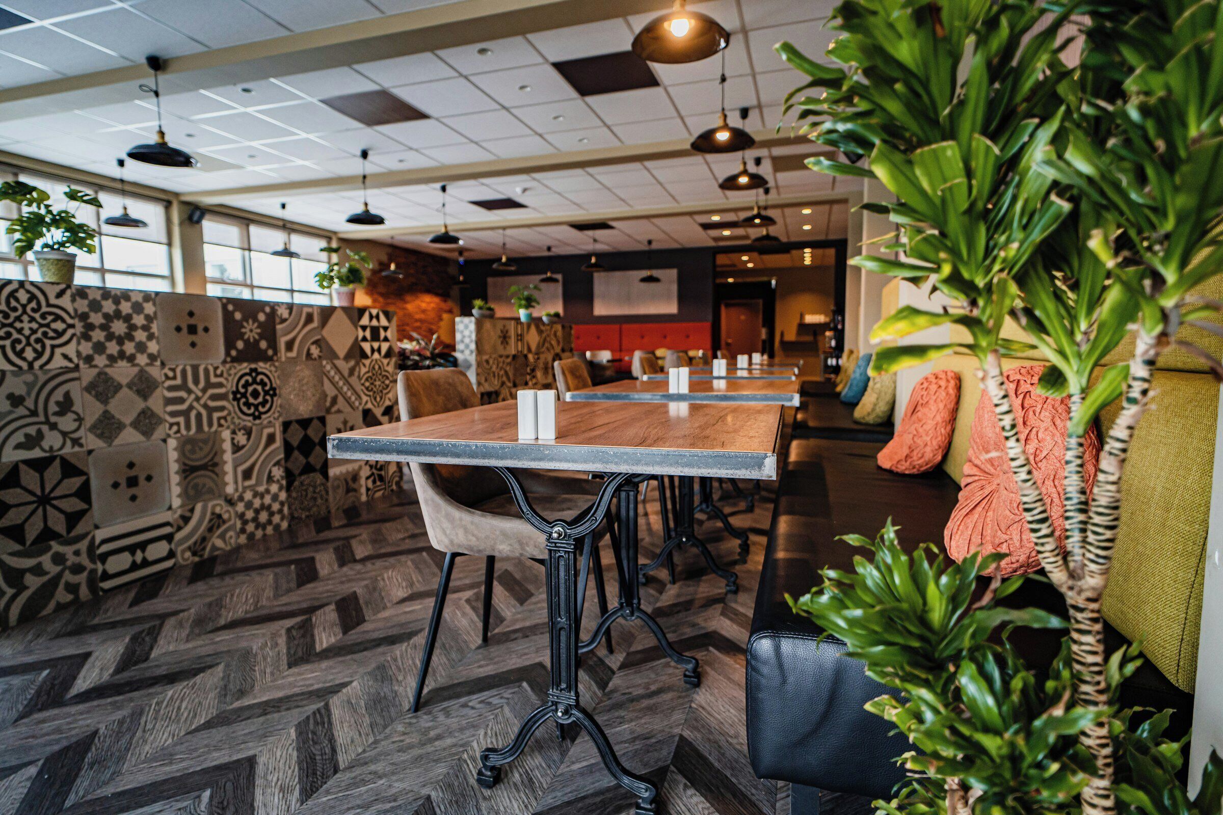 A modern conference room with patterned walls, wooden tables, and black chairs.