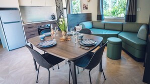 Una cocina moderna con comedor, sofá y ventana con vista a zonas verdes.
