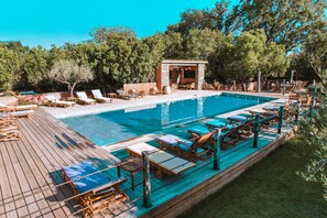 Ein Swimmingpool mit Liegestühlen und einer Holzterrasse.