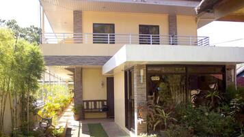 Guests can enjoy a balcony with a garden view from the upper level of this building, featuring a brick and stucco exterior.