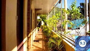 A corridor with a chain-link fence, potted plants, and a clear view of the outside. - Haisa Apartment (Coron)