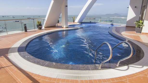 Une piscine avec vue sur la mer et les bateaux.