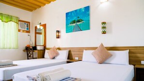 A hotel room with two beds, a painting of a tropical island, and a wooden ceiling.