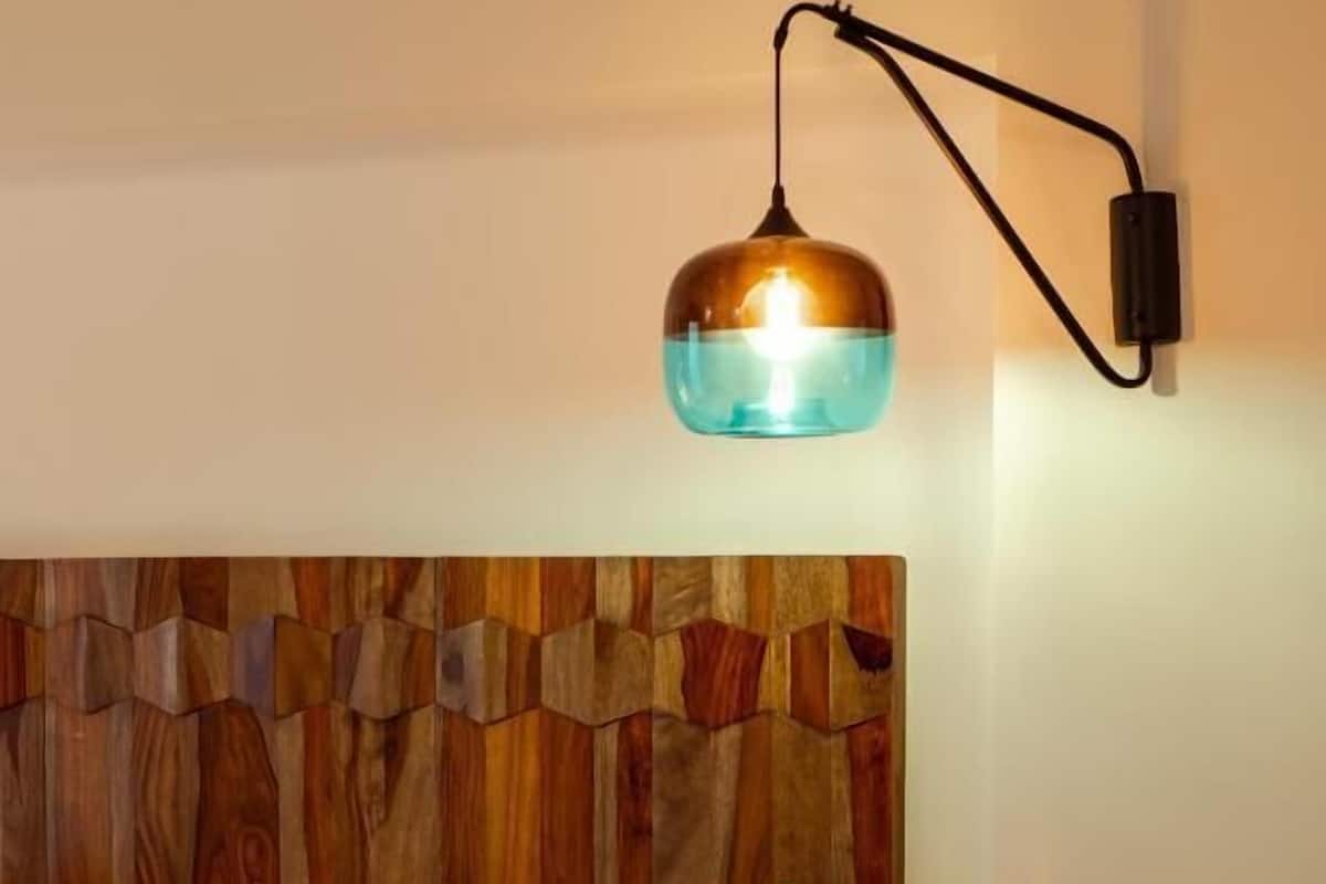 Ein Bett mit Holz-Kopfseitenverkleidung, zwei Kissen und einem Nachttisch.
