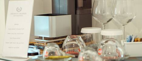 A breakfast setup with a coffee machine, wine glasses, and a menu.