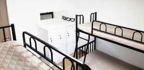 Un dormitorio con literas, un armario y un espejo.