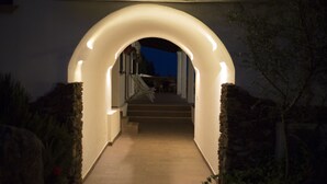 An arched entrance with a lighted pathway leading to a staircase. - Country House S'Ozzastru (Dorgali)