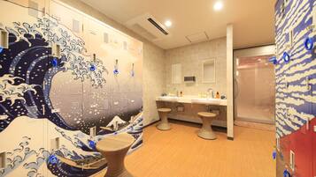 A bathroom with a wave-themed design, a sink area, and a shower.