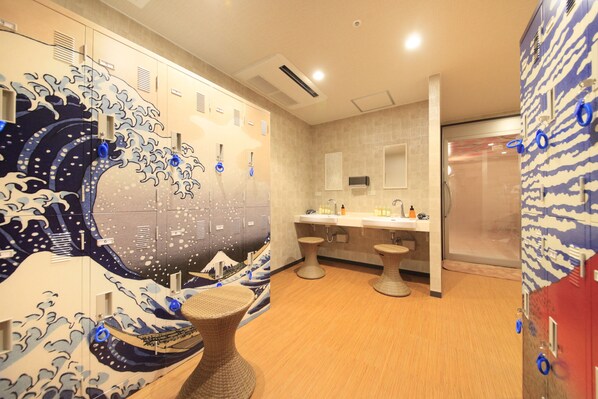 A bathroom with a wave-themed design, a sink area, and a shower.