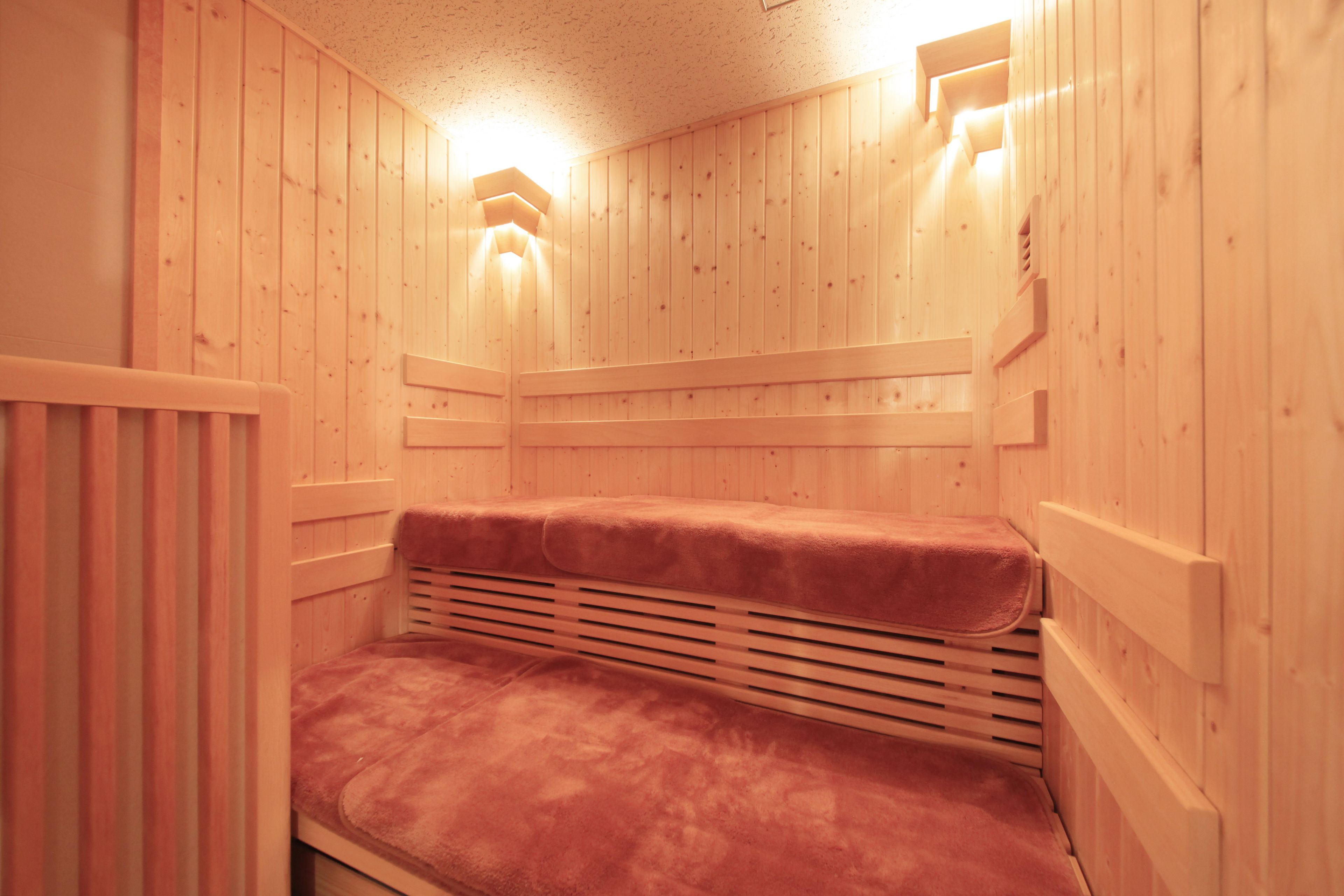 Una sauna de madera con banco y paredes de listones.