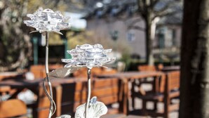A table with a metal flower centerpiece, red napkins, and cutlery. - Hotel Il Mulino (Seekirchen am Wallersee)