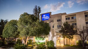 Hotel 'Garden Court', con un letrero, rodeado de árboles y un jardín paisajístico.
