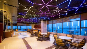 Un interior moderno con lámparas de techo geométricas, una zona de bar y asientos con vistas.