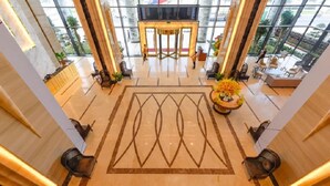 A spacious lobby with a central reception desk, large windows, and a patterned floor. - Muong Thanh Luxury Da Nang Hotel (Da Nang)