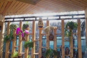 A wooden pergola with multiple levels of planters containing various plants and flowers.