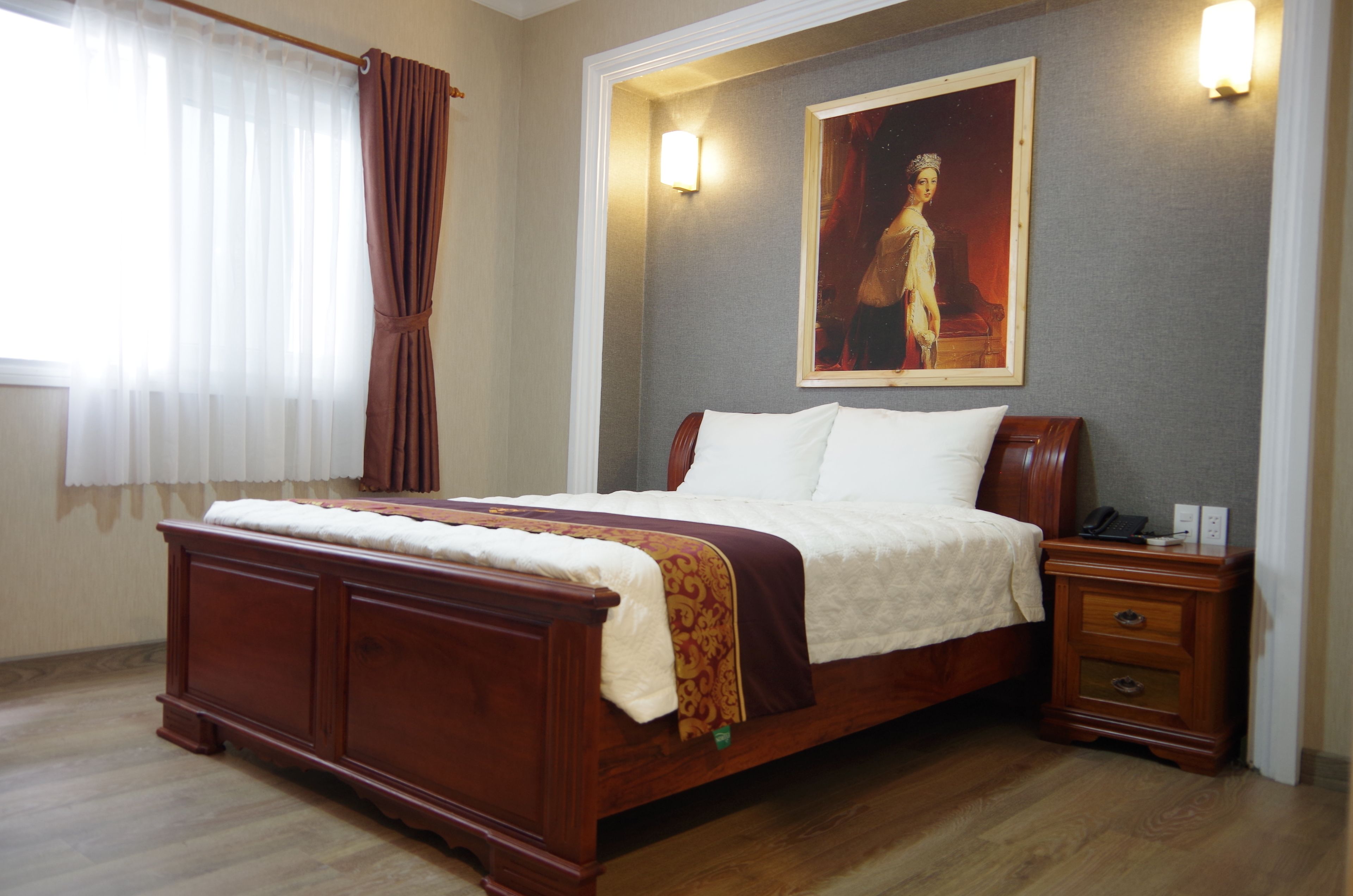 A bedroom with a wooden bed, a nightstand, and a painting on the wall.