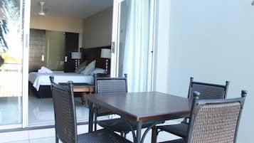Una habitación de hotel con una cama, un escritorio y un área de comedor con sillas.