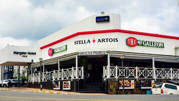 A building with signs for 'Stella Artois' and 'The Galleon' restaurants, a covered outdoor seating area, and a 'Margate Hotel' sign.