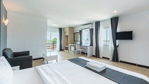 A hotel room with a bed, a desk, a chair, a TV, and a balcony view. - Le Nara Residence (Pattaya)