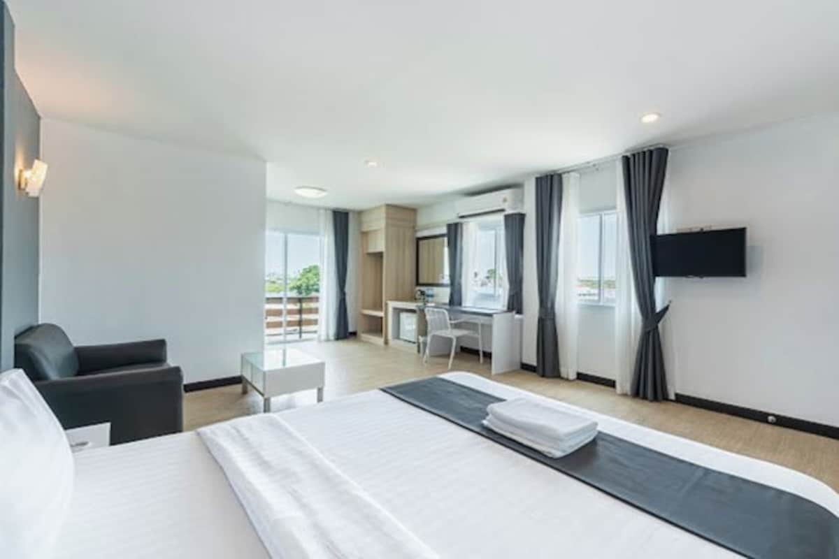 Une chambre d’hôtel avec un lit, un bureau, une chaise, une télévision et une fenêtre.