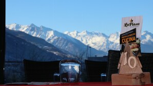 A table with a clear glass, a menu sign, and a mountain view in the background. - Lazy Bee Camping Village (Quart)