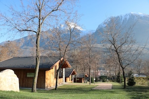 Una hilera de cabañas de madera con una montaña de fondo.