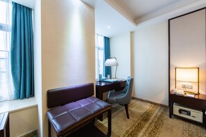 Habitació d'hotel amb escriptori, cadira i una petita zona d'estar.