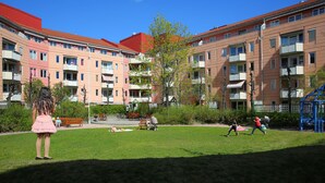 Un immeuble résidentiel doté de nombreux balcons et d’un espace de jeux pour enfants situé à l’avant.