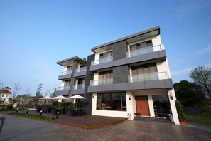 A modern multi-story building with a flat roof, large windows, and a balcony. - 193 County Garden BnB (Ji'an)