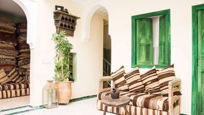 A traditional Moroccan interior with a sofa, a potted plant, and a lantern. - Riad el Marah (Marrakech)