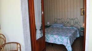 A bedroom with a four-poster bed, a chandelier, and a mirror. - Villa Fiumetto (Pietrasanta)