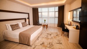 Una habitación de hotel con cama, escritorio y ventana grande.