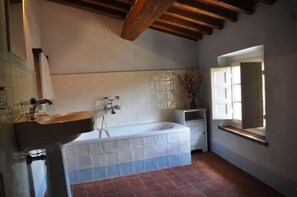 Ein Badezimmer mit Waschbecken, Badewanne und Fenster.