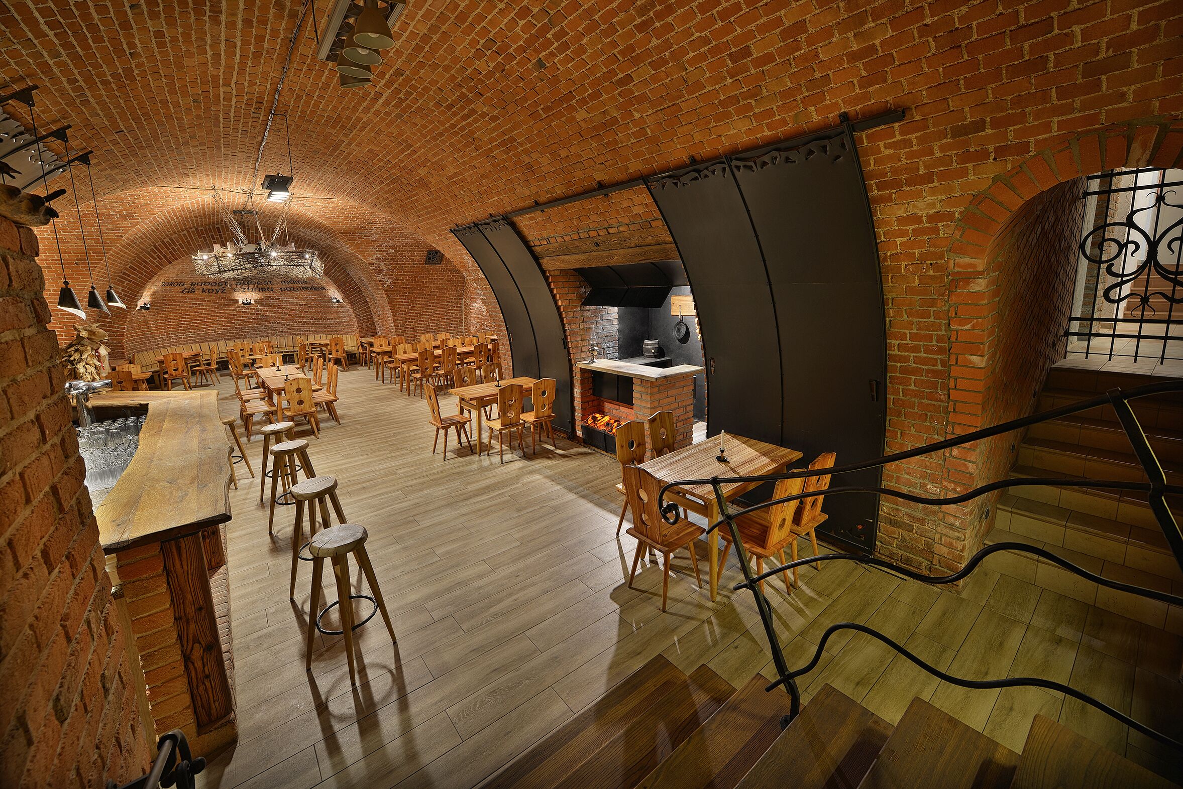 Un restaurant amb parets de maó, taules i cadires de fusta.