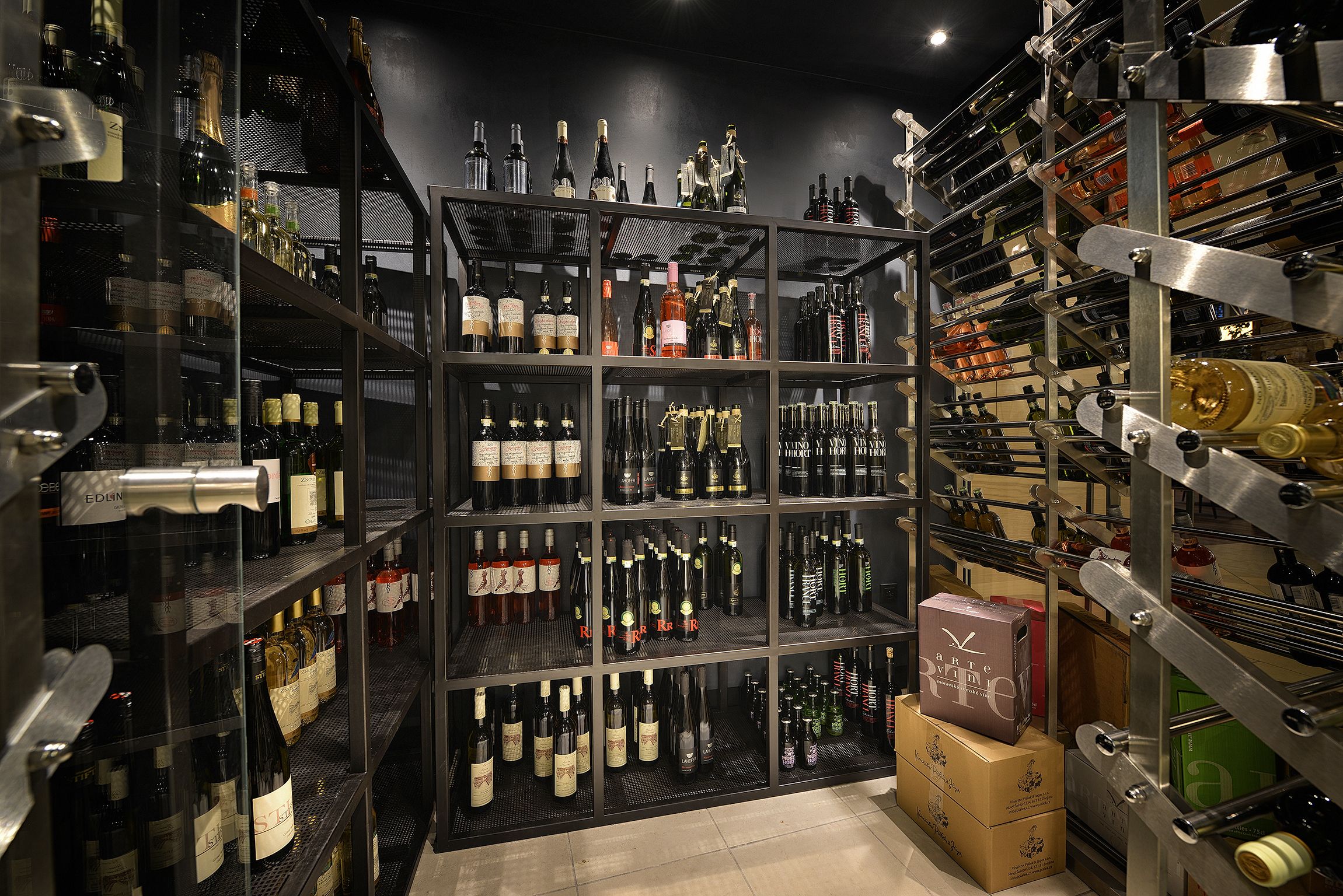 A wine cellar with multiple shelves stocked with various bottles of wine.